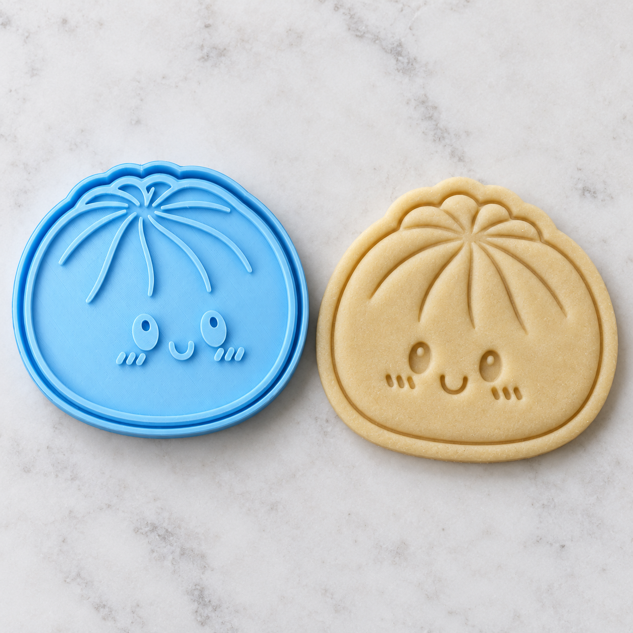 Blue dumpling stamp beside its recessed impression in raw cookie dough