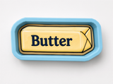 A blue tray with a yellow butter stick on it.