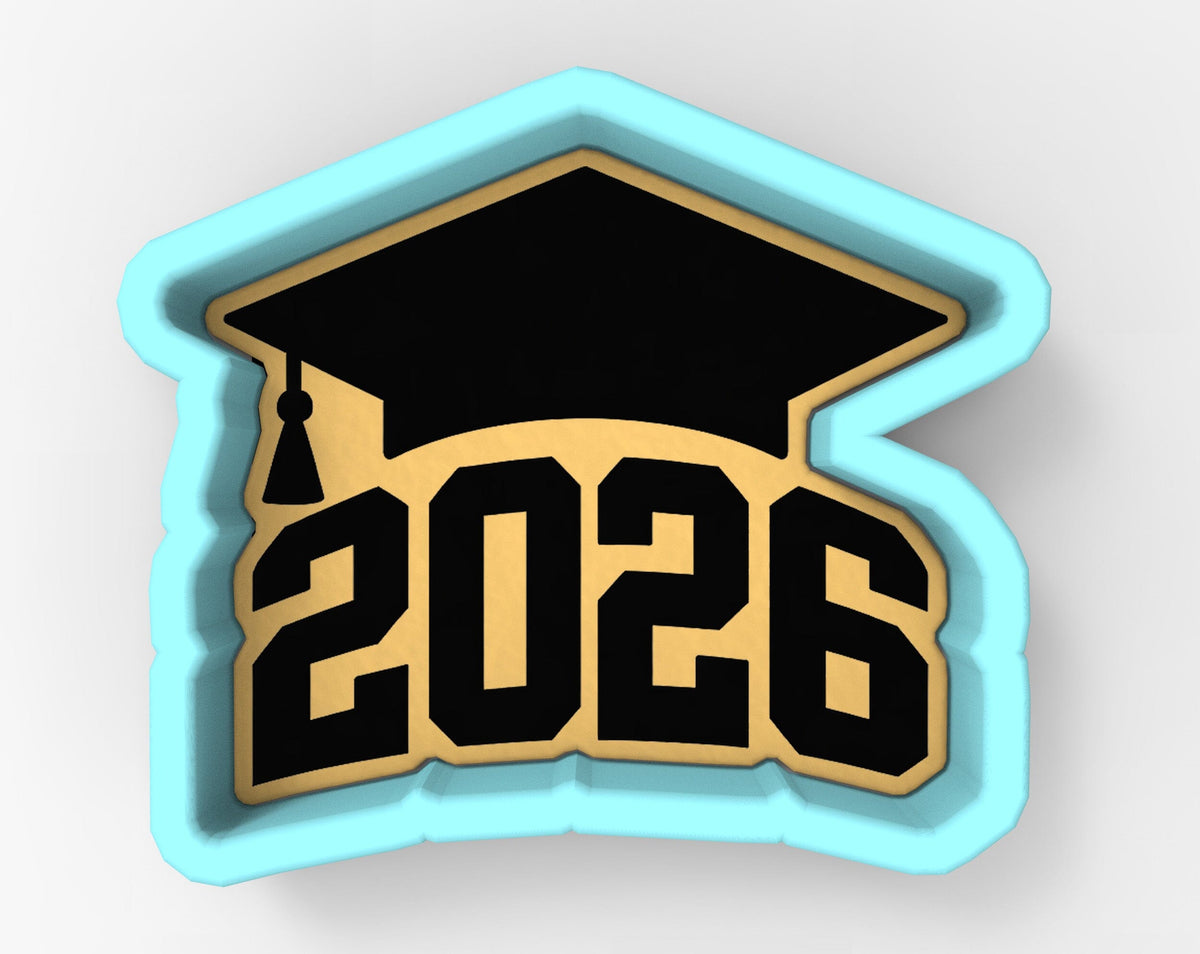 A graduation cap-shaped cookie cutter with the number "2026" printed on it.