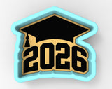 A graduation cap-shaped cookie cutter with the number "2026" printed on it.
