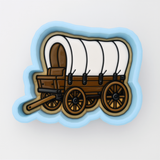 A cookie cutter-shaped illustration of a covered wagon, a traditional mode of transportation used by pioneers in the United States during the 19th century.