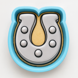 A blue cookie cutter shaped like a horseshoe, with a yellow interior.