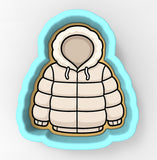 A cookie cutter in the shape of a winter coat with a hood.
