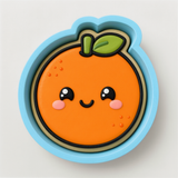 A round cookie cutter in the shape of an orange with a smiling face and a green leaf on top.