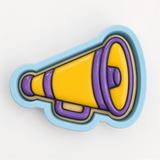 A 3D printed cookie cutter in the shape of a megaphone, with a yellow body and purple accents.