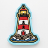 A cookie cutter shaped like a lighthouse, with a red and white striped body, a yellow light at the top, and a red door at the bottom.