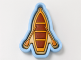 A cookie cutter shaped like a boat with paddles, designed to cut out cookies in the shape of boats.