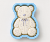 A blue and white teddy bear cookie cutter with a floral design on it.