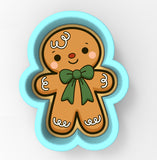 A cookie cutter in the shape of a gingerbread man with a bow tie.
