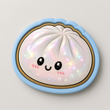 A whimsical illustration of a round, white object with a face and eyes, surrounded by a blue border and adorned with sparkles.