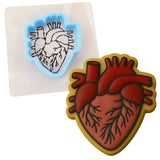 a heart shaped cookie cutter next to a cookie cutter