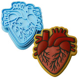 two cookie cutters with a heart and a human heart