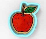 A red apple with a green leaf is depicted in a cookie cutter shape.