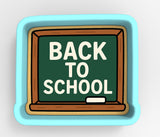 A blue chalkboard with the text "BACK TO SCHOOL" written on it.