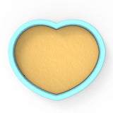 a heart shaped cookie tin with a cookie inside