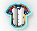 A cookie cutter in the shape of a baseball jersey, with red, white, and blue stripes.