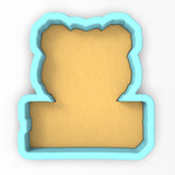 a cookie cutter with a piece of bread in the shape of a bear