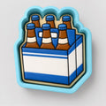 A blue and white cookie cutter shaped like a six-pack of beer bottles.