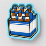 A blue and white cookie cutter shaped like a six-pack of beer bottles.