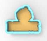 A cookie cutter in the shape of a person's head, with a light brown color and a blue outline.