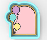 A 3D rendering of a blue cookie cutter with a pink interior, featuring three colorful balloons floating inside the cutter.