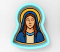 A blue oval-shaped cookie cutter depicting a woman with long brown hair wearing a blue robe and a halo.