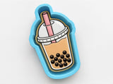 A blue cookie cutter shaped like a bubble tea cup with a straw and a layer of bubble tea inside.