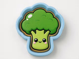A cartoon-style broccoli with a smiling face, set against a plain white background.
