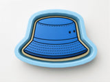 A blue bucket hat-shaped cookie cutter is shown against a white background.