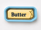 A blue tray with a yellow butter stick on it.