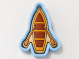 A cookie cutter shaped like a boat with paddles, designed to cut out cookies in the shape of boats.