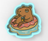 a sticker of a brown bear sitting on a donut