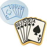 a cookie decorated with playing cards and a cookie cutter