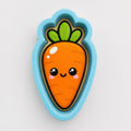 A cartoon carrot cookie cutter with a smiling face and a green stem.