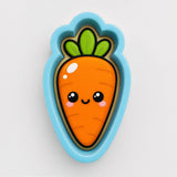 A cartoon carrot cookie cutter with a smiling face and a green stem.