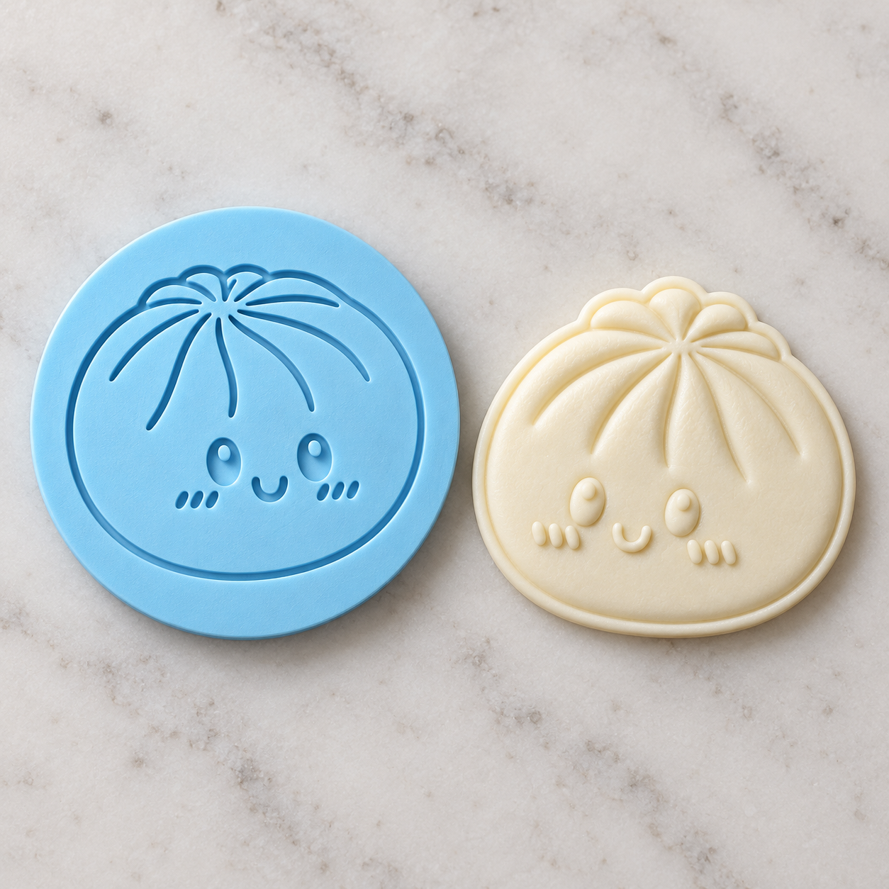 Blue dumpling debosser beside its raised three-dimensional fondant result