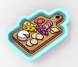 a wooden cutting board topped with cheese and crackers