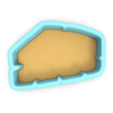 a cookie cutter with a cookie in the shape of a house