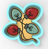A cookie cutter in the shape of a clover with four colored lights attached to it.