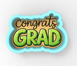 A cookie cutter-shaped graphic with the text "CONGRATS GRAD" in a stylized font.