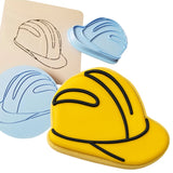 a cookie shaped like a helmet next to a cookie cutter