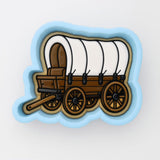 A cookie cutter-shaped illustration of a covered wagon, a traditional mode of transportation used by pioneers in the United States during the 19th century.