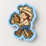 A cookie cutter in the shape of a cowboy riding a horse.