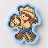 A cookie cutter in the shape of a cartoon girl riding a horse.