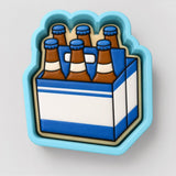 A blue and white cookie cutter shaped like a six-pack of beer bottles.