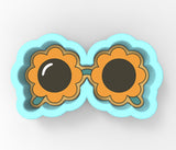 a pair of sunflower shaped cookie cutters sitting on top of each other