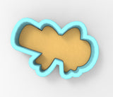 A cookie cutter in the shape of a bird, with a light brown body and a blue outline.