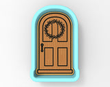 A wooden door with a wreath design on it, set within a blue frame.