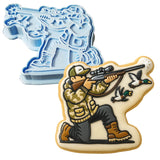 a cookie cutter and a cookie shaped like a man with a gun