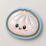 A whimsical illustration of a round, white object with a face and eyes, surrounded by a blue border and adorned with sparkles.